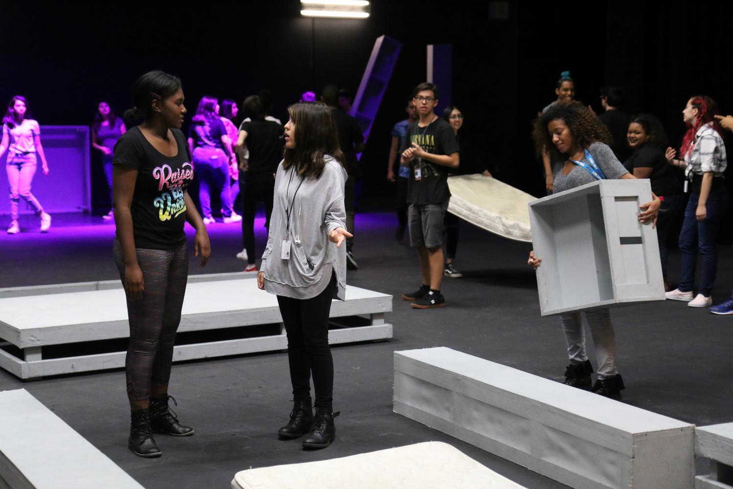 Junior Kayla Brown (left) and Alexis Castillo (right) discuss how the set should be set up to display a perfect scene. 