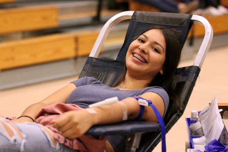 Senior Brianda  Aguilar happily donates blood in the small gym Friday morning Sept. 27. 