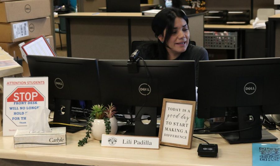 Receptionist Lili Padilla monitors people wishing to enter the building through the camera at her desk, as new security system is implemented. Photo by Caitlyn Brabo