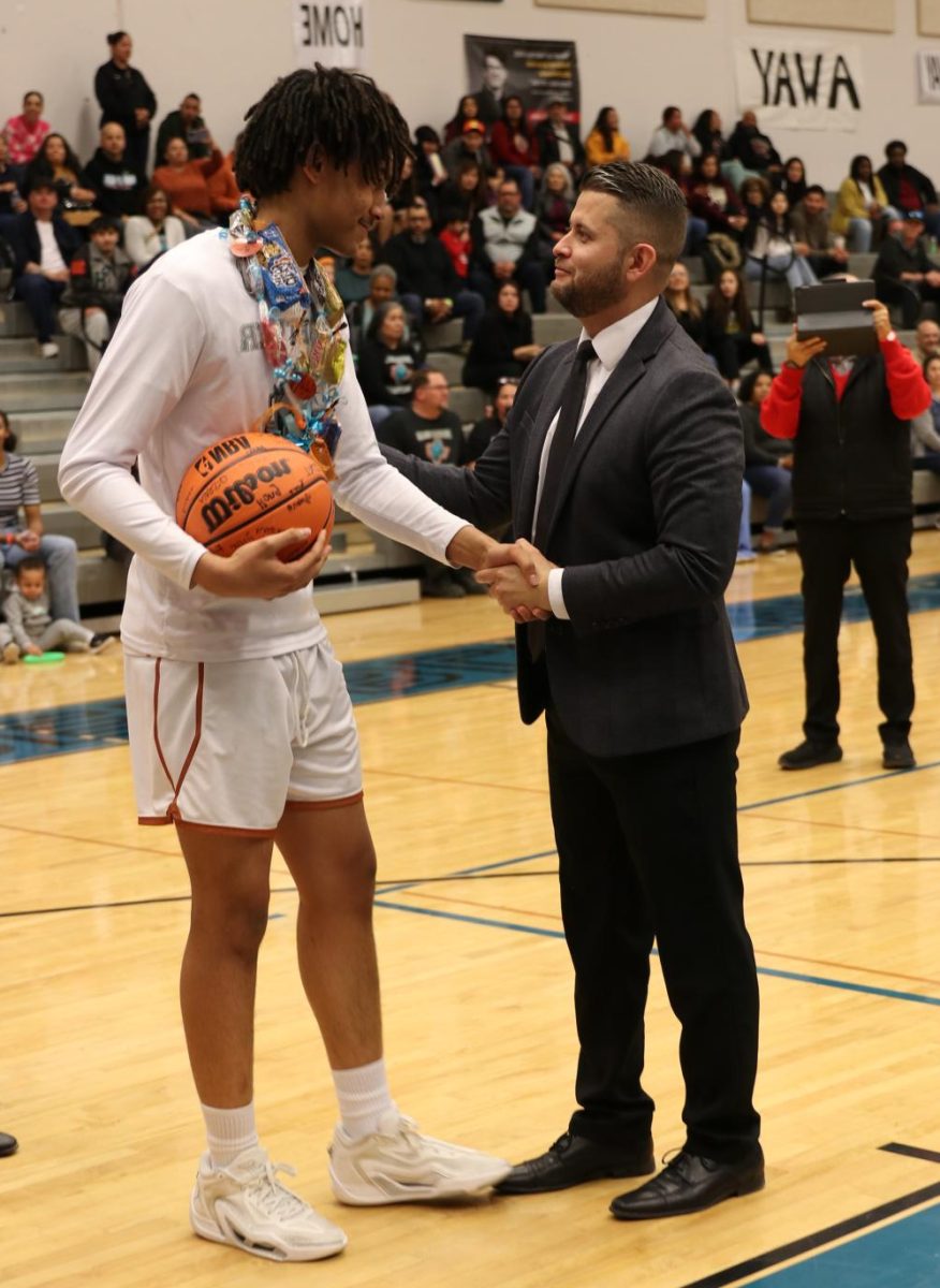 Coach David Hernandez congratulates player during senior night 2024. File photo by Caitlyn Griffitts 